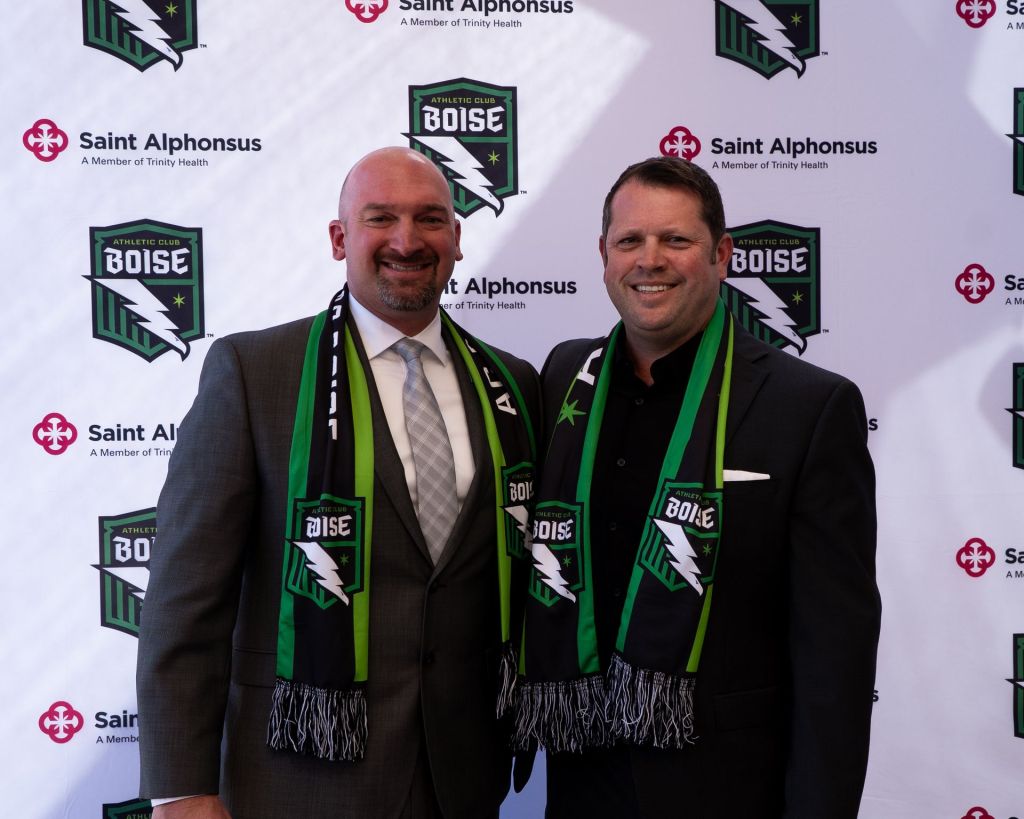 David McFadyen, CEO of Saint Alphonsus, and Brad Stith, CEO of Athletic Club Boise, standing together at a branded backdrop.