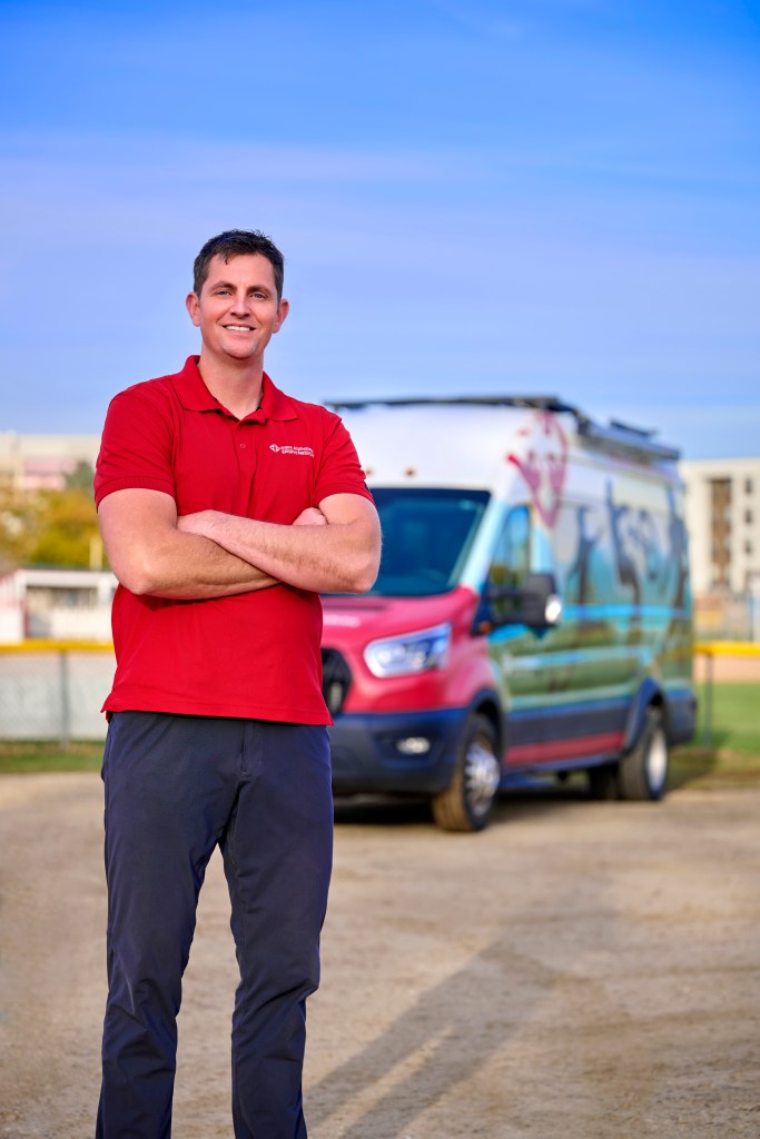 Team doctor Derek Kunz standing in front of a Saint Alphonsus medical van.