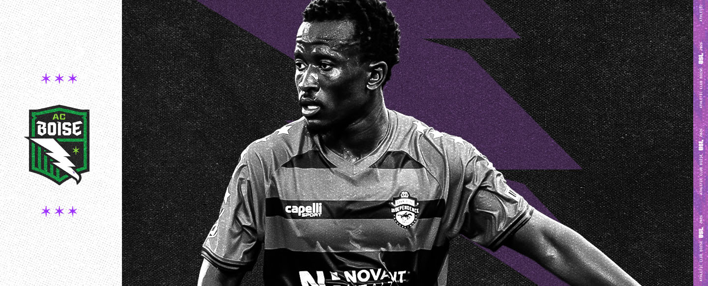 Black and white photo of Tumi Moshobane playing soccer with an Athletic Club Boise branded background